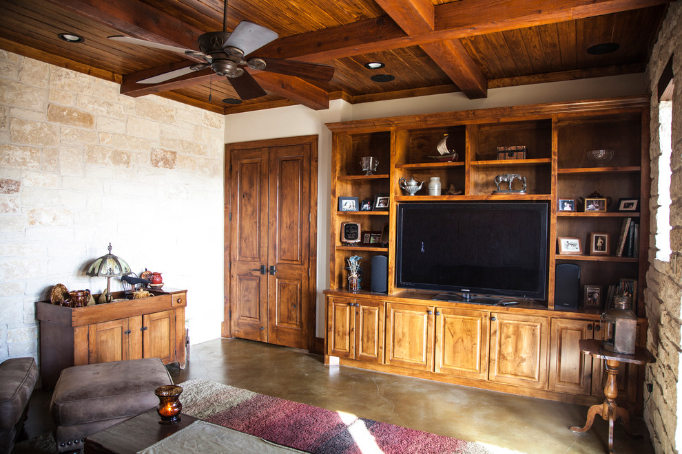 Ejemplo de despacho rural de tamaño medio con suelo de cemento, paredes beige, suelo marrón y vigas vistas