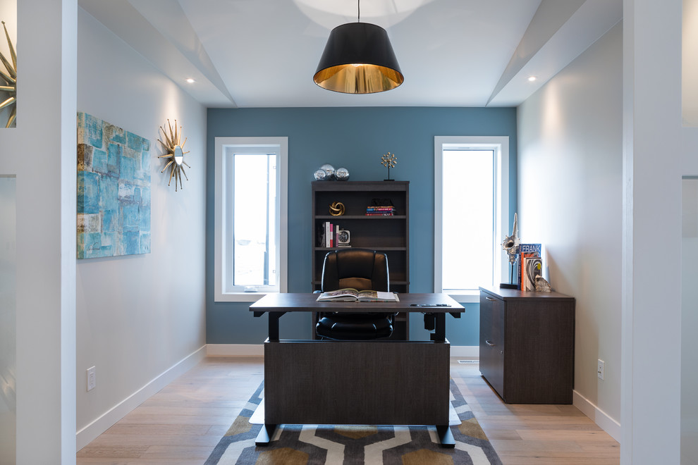 他の地域にある広いトラディショナルスタイルのおしゃれな書斎 (青い壁、ラミネートの床、自立型机) の写真