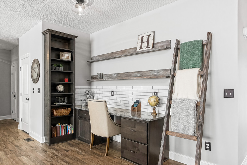 Idée de décoration pour un bureau champêtre avec un mur gris, un sol en bois brun, un bureau intégré et un sol marron.