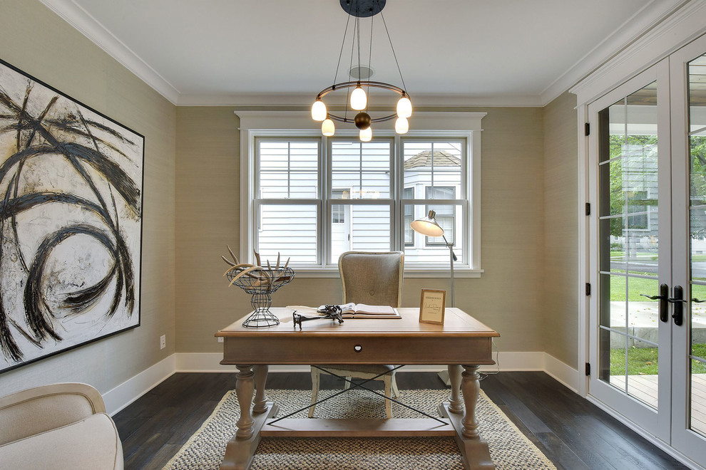 Foto de despacho tradicional renovado de tamaño medio con paredes beige, suelo de madera oscura y escritorio independiente