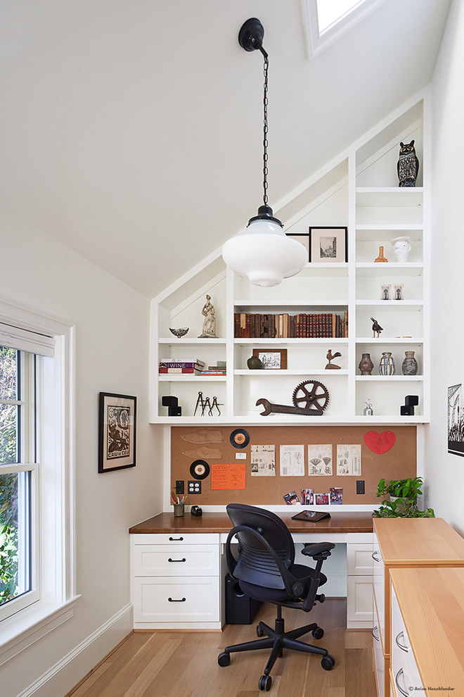 Ejemplo de despacho tradicional renovado de tamaño medio sin chimenea con paredes blancas, suelo de madera clara y escritorio empotrado