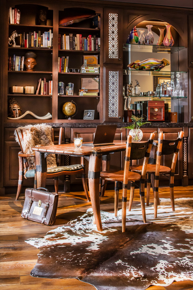 Example of a mid-sized mountain style freestanding desk medium tone wood floor and brown floor home office library design in Other with beige walls and no fireplace
