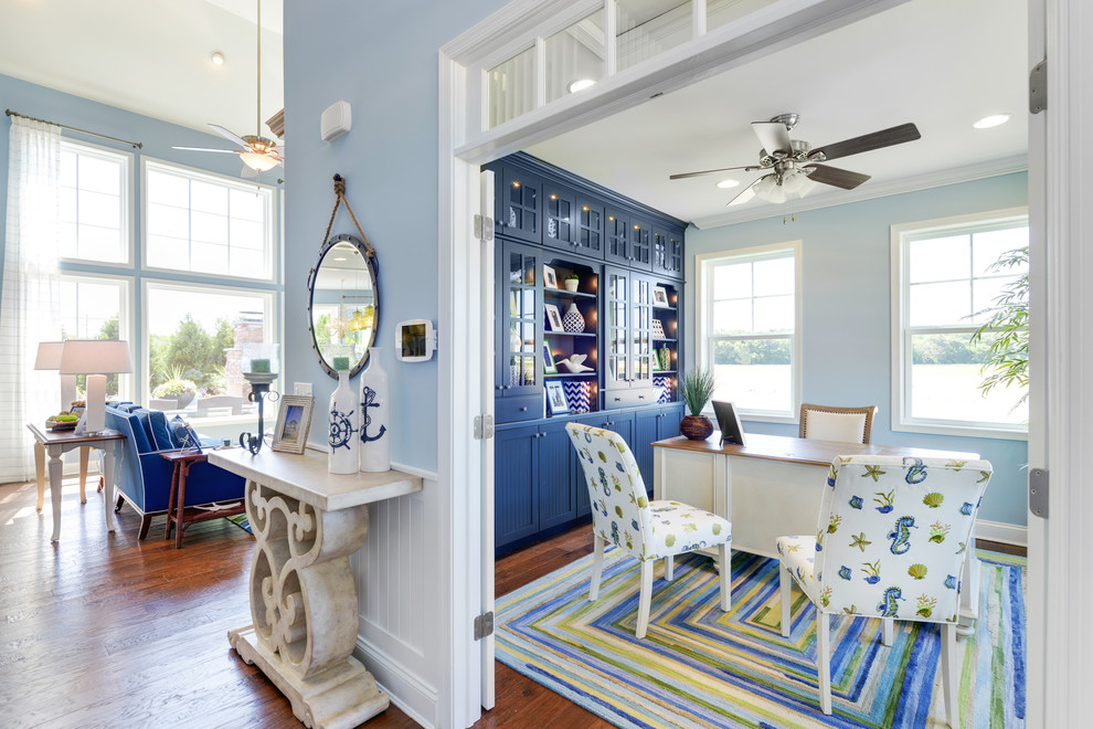 Idee per un ufficio stile marinaro con pareti blu, pavimento in legno massello medio e scrivania autoportante