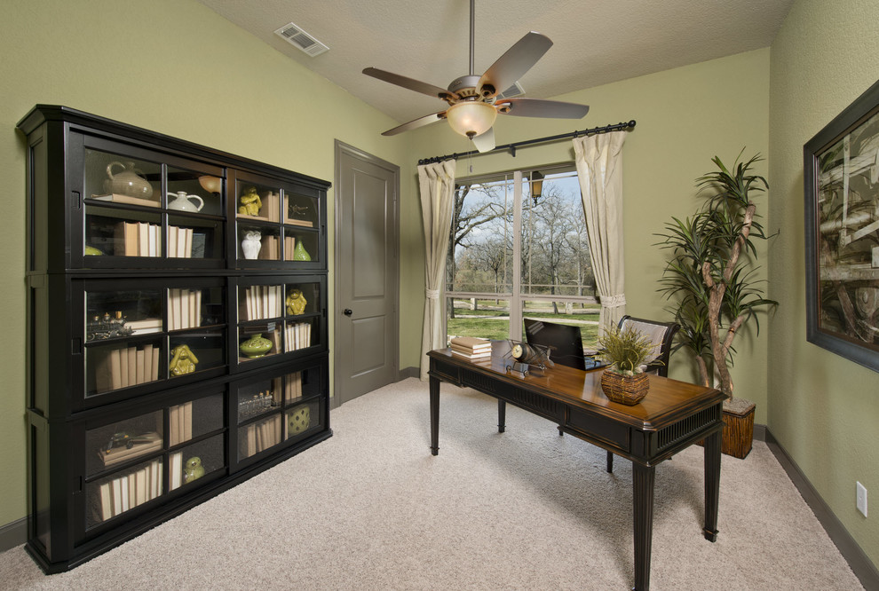 Exempel på ett mellanstort klassiskt hemmabibliotek, med gröna väggar, heltäckningsmatta, ett fristående skrivbord och grått golv
