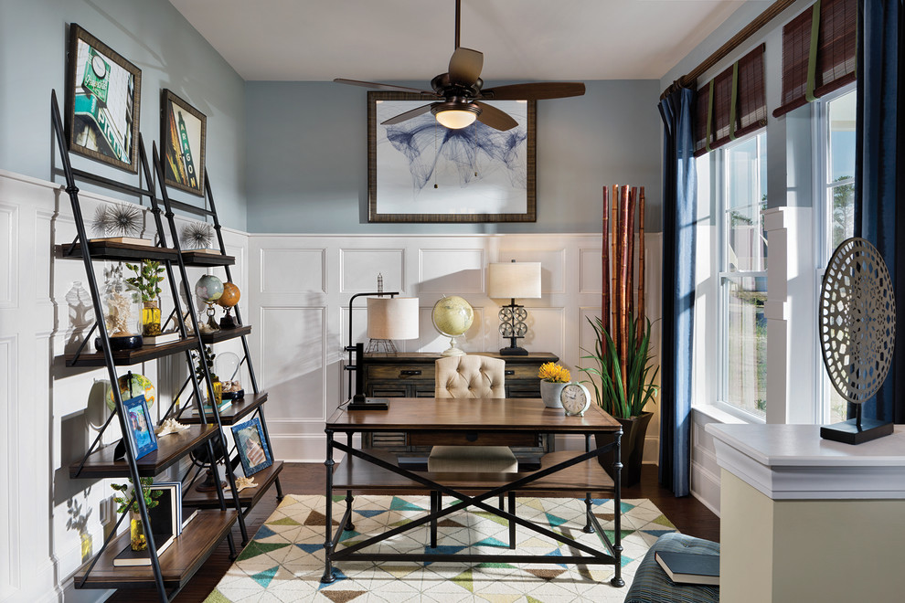 Klassisches Arbeitszimmer ohne Kamin mit Arbeitsplatz, blauer Wandfarbe, dunklem Holzboden und freistehendem Schreibtisch in Charleston