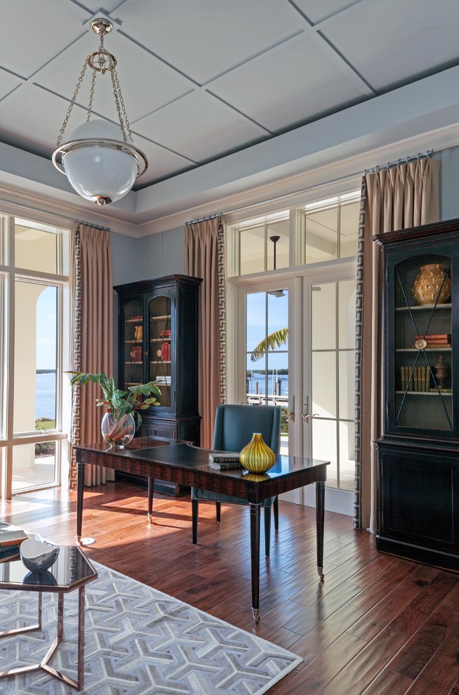 Ejemplo de despacho clásico renovado grande con paredes azules, suelo de madera en tonos medios y escritorio independiente