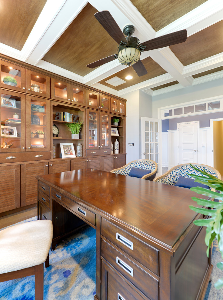 This is an example of a beach style study in Other with blue walls, medium hardwood flooring and a freestanding desk.