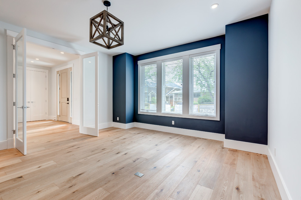 Idee per un grande atelier tradizionale con pareti blu, parquet chiaro e pavimento marrone