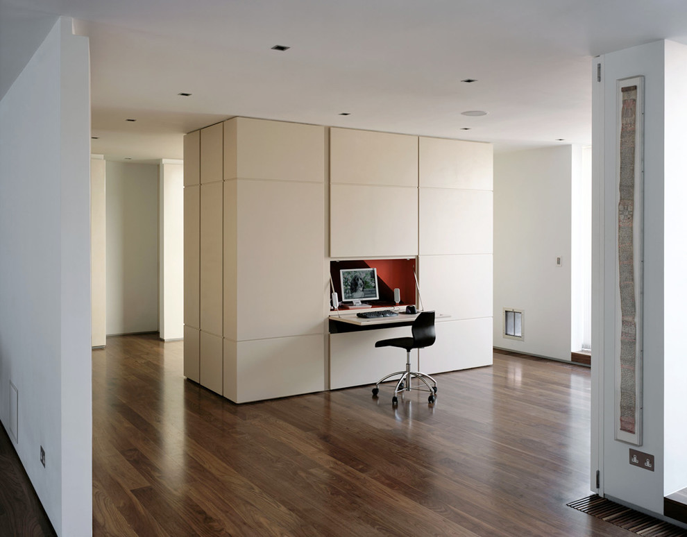 Imagen de despacho actual pequeño con paredes beige, suelo de madera oscura y escritorio empotrado