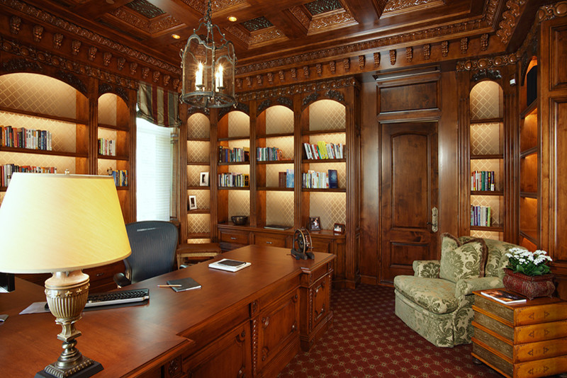 Inredning av ett klassiskt stort hemmabibliotek, med bruna väggar, heltäckningsmatta, ett fristående skrivbord och rött golv