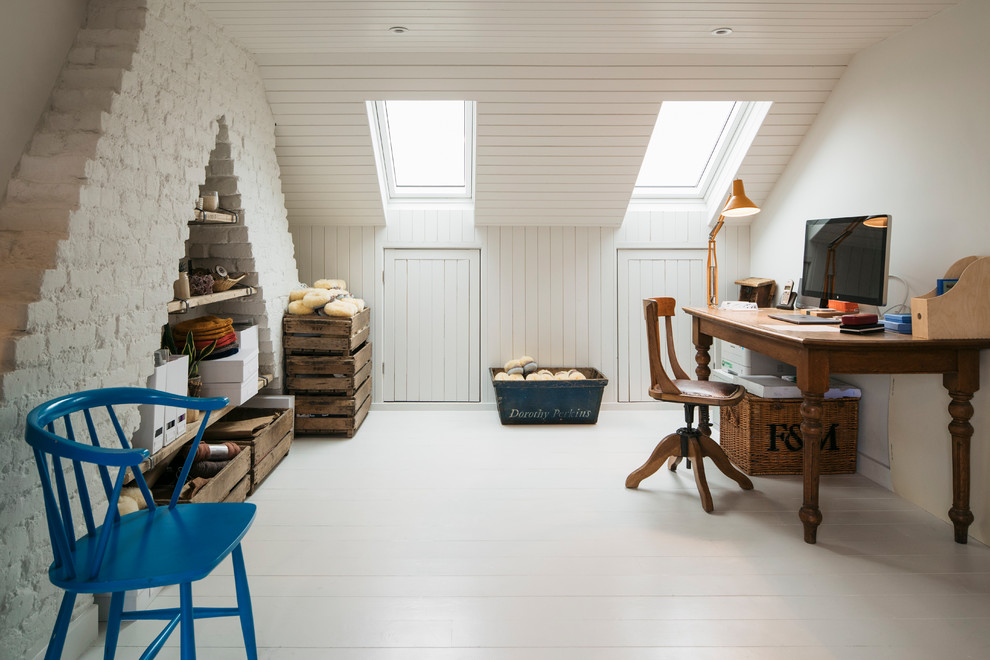 На фото: рабочее место среднего размера в стиле шебби-шик с белыми стенами, деревянным полом, отдельно стоящим рабочим столом и белым полом с