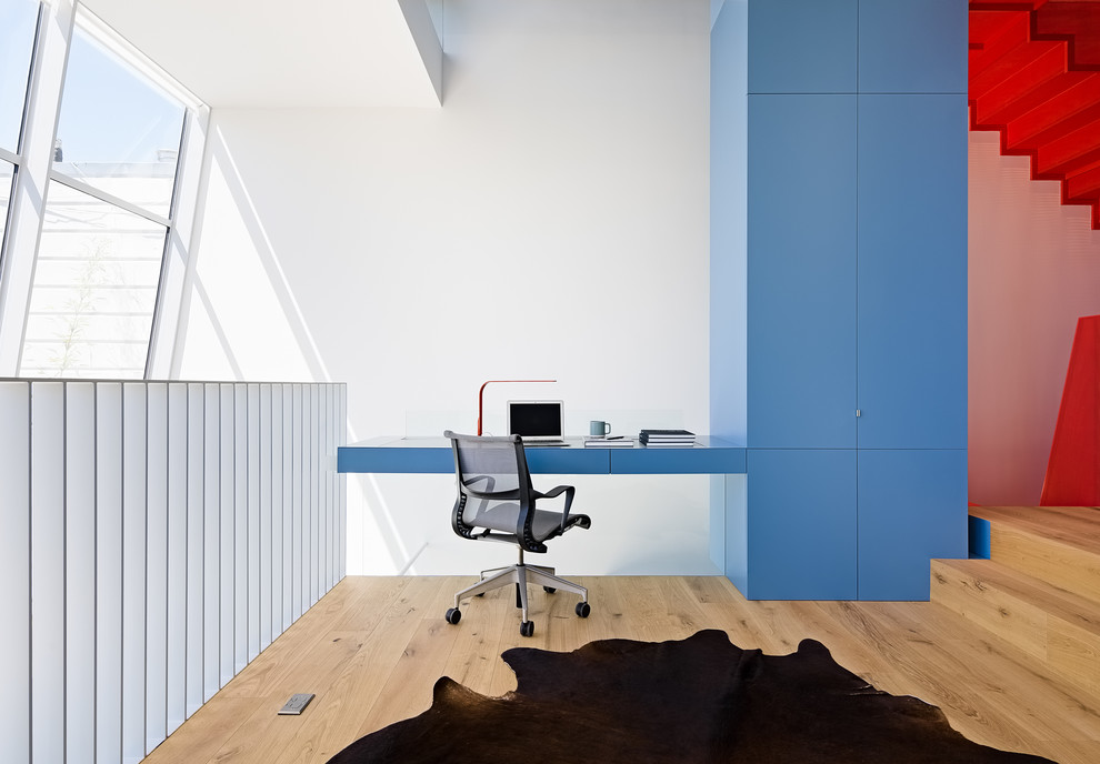 Aménagement d'un petit bureau contemporain avec un mur blanc, parquet clair, un bureau intégré et un sol beige.