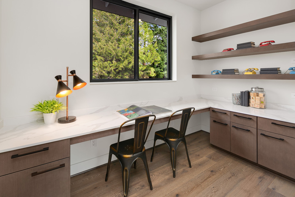 Mittelgroßes Modernes Arbeitszimmer mit weißer Wandfarbe, braunem Holzboden, Einbau-Schreibtisch und grauem Boden in Seattle