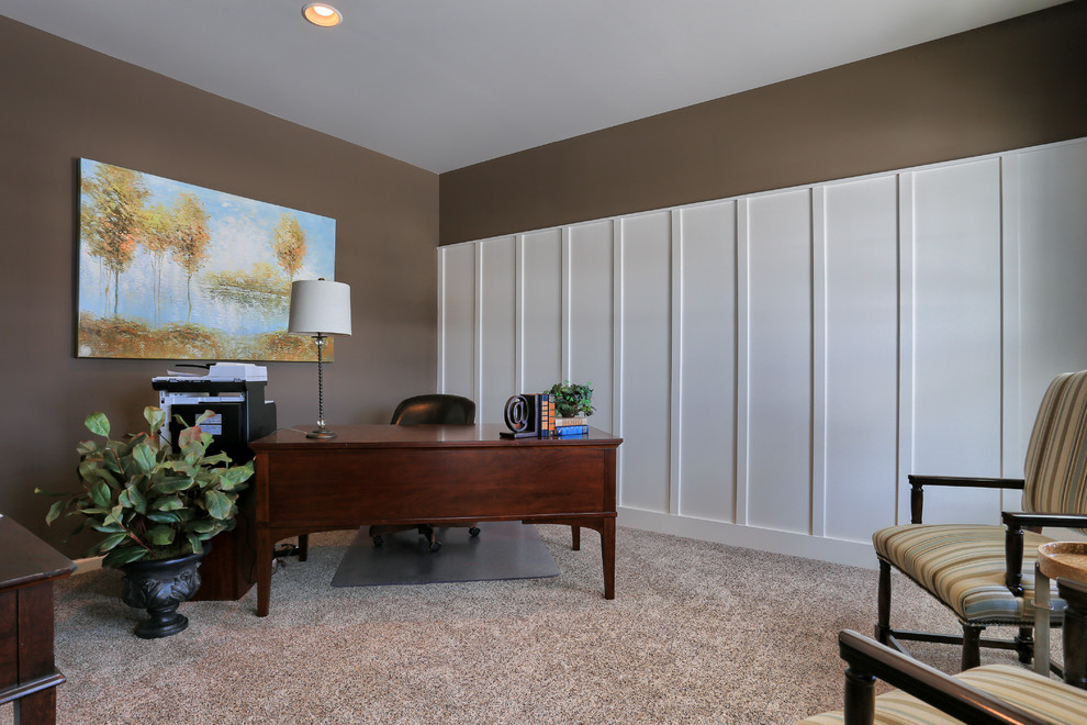 Mittelgroßes Klassisches Arbeitszimmer mit Arbeitsplatz, brauner Wandfarbe, Teppichboden und freistehendem Schreibtisch in Sonstige