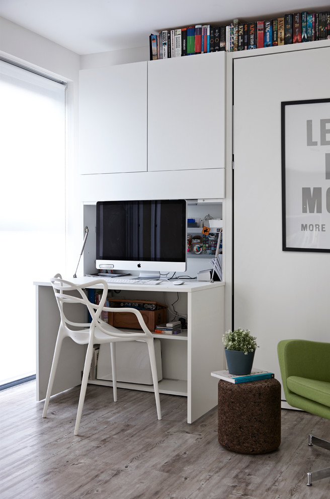Modernes Arbeitszimmer mit Arbeitsplatz, weißer Wandfarbe, Einbau-Schreibtisch und hellem Holzboden in London