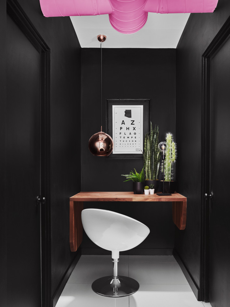 Inspiration för små moderna hemmabibliotek, med svarta väggar, ett inbyggt skrivbord och grått golv