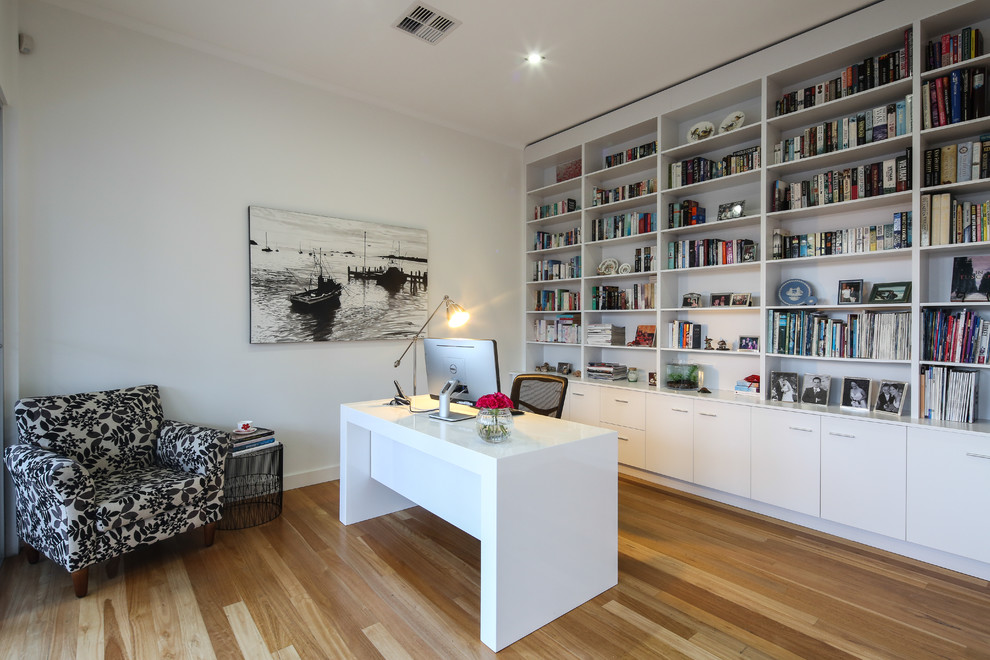 Großes Klassisches Arbeitszimmer mit Arbeitsplatz, weißer Wandfarbe, braunem Holzboden und freistehendem Schreibtisch in Adelaide