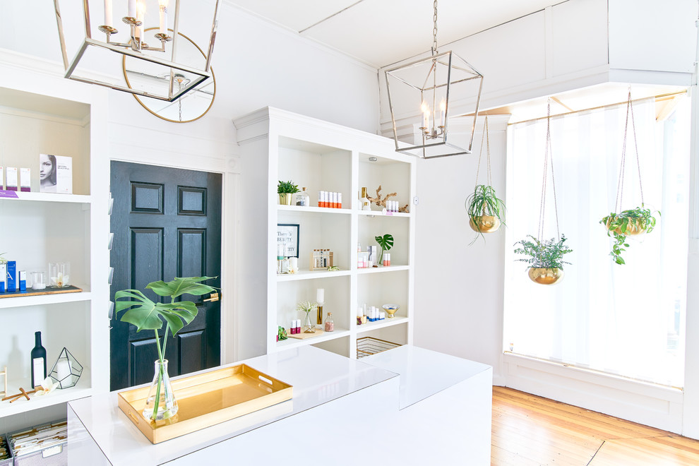 Kleines Skandinavisches Arbeitszimmer mit weißer Wandfarbe, braunem Holzboden, Einbau-Schreibtisch und braunem Boden in Providence