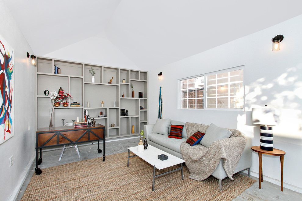ロサンゼルスにあるカントリー風のおしゃれな書斎 (白い壁、自立型机、グレーの床) の写真