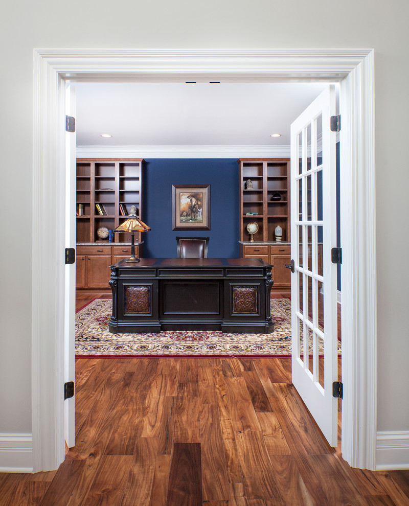 Aménagement d'un bureau classique avec un mur bleu, un sol en bois brun et un bureau indépendant.