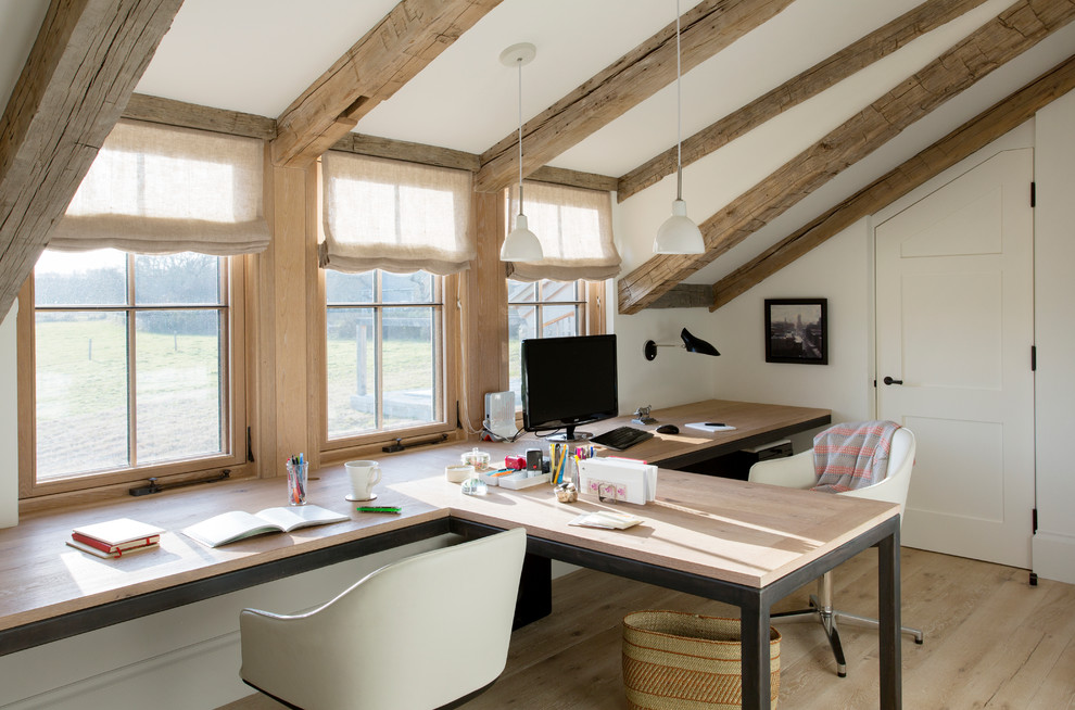 Example of a large farmhouse built-in desk light wood floor and brown floor study room design in Boston with white walls