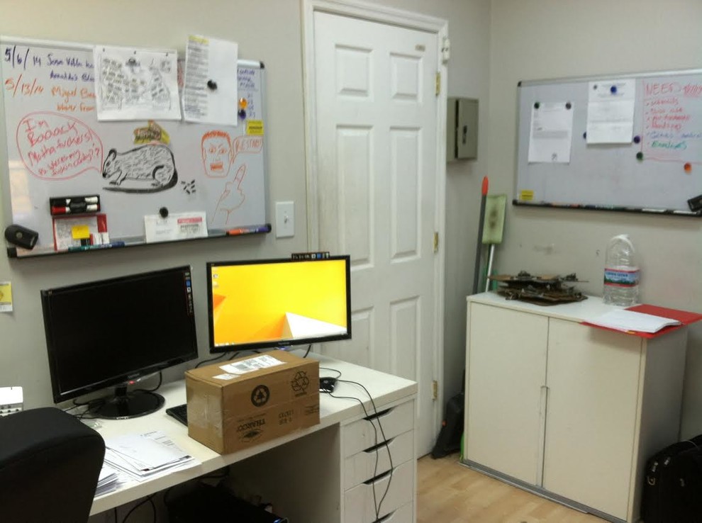 Imagen de despacho actual de tamaño medio con paredes grises, suelo de madera clara y escritorio independiente