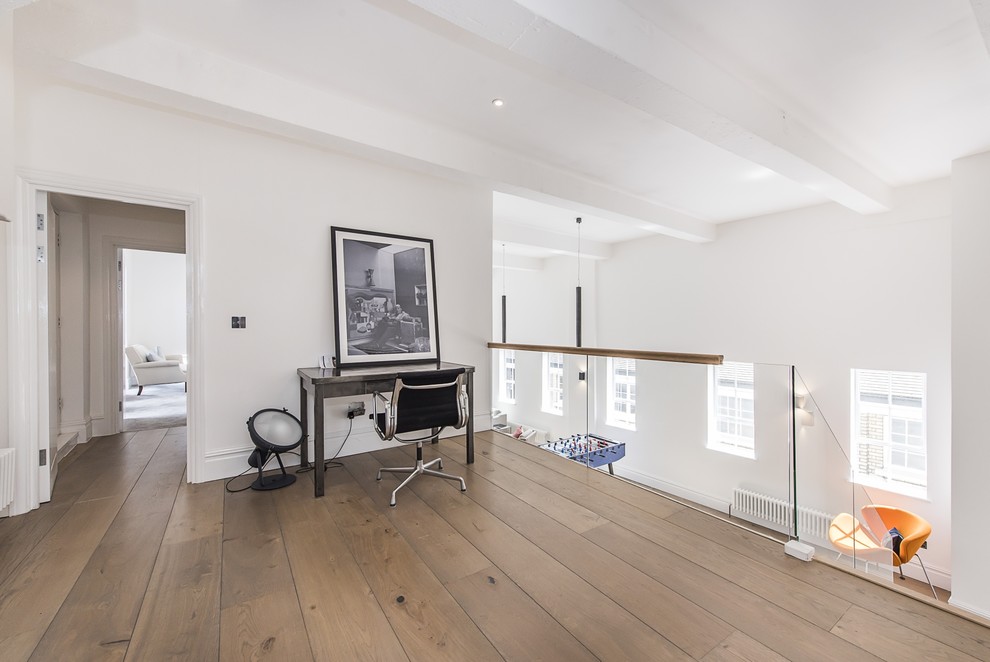Imagen de despacho minimalista grande con paredes blancas y suelo de madera en tonos medios