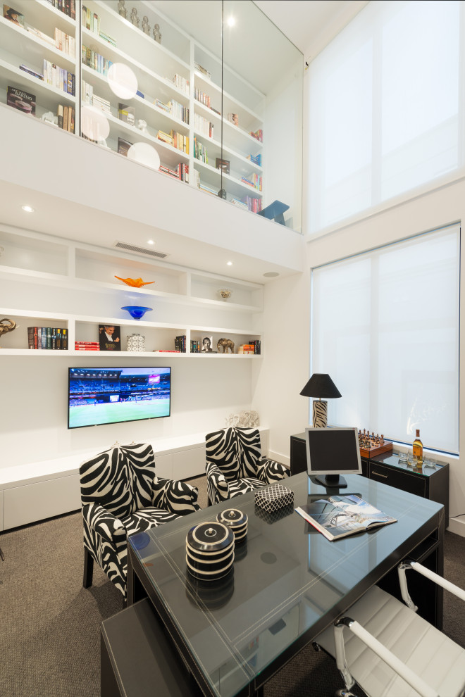 This is an example of a large contemporary study in Melbourne with white walls, carpet, a freestanding desk and grey floors.
