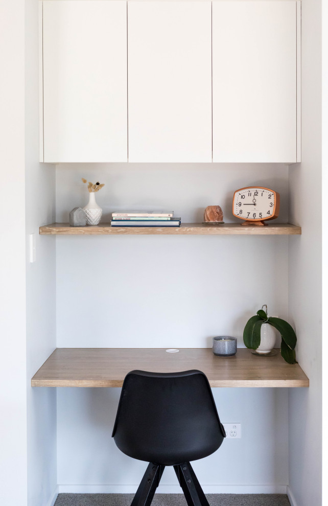 Idee per un piccolo ufficio minimal con pareti grigie, moquette, scrivania incassata e pavimento grigio