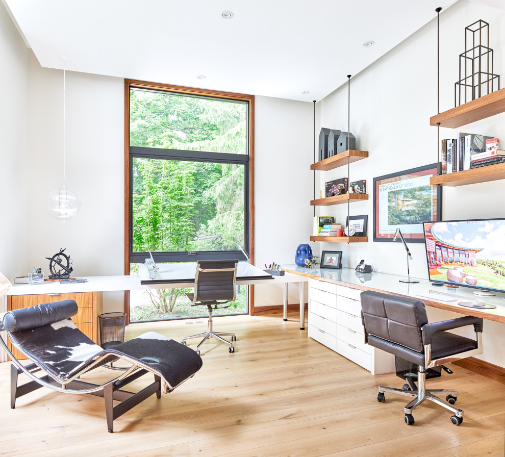 Ejemplo de despacho contemporáneo de tamaño medio sin chimenea con paredes blancas, suelo de madera clara, escritorio empotrado y suelo beige
