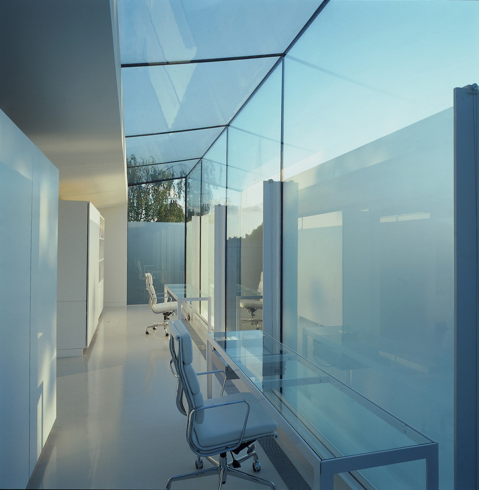 Стильный дизайн: большое рабочее место в современном стиле с белыми стенами и отдельно стоящим рабочим столом - последний тренд