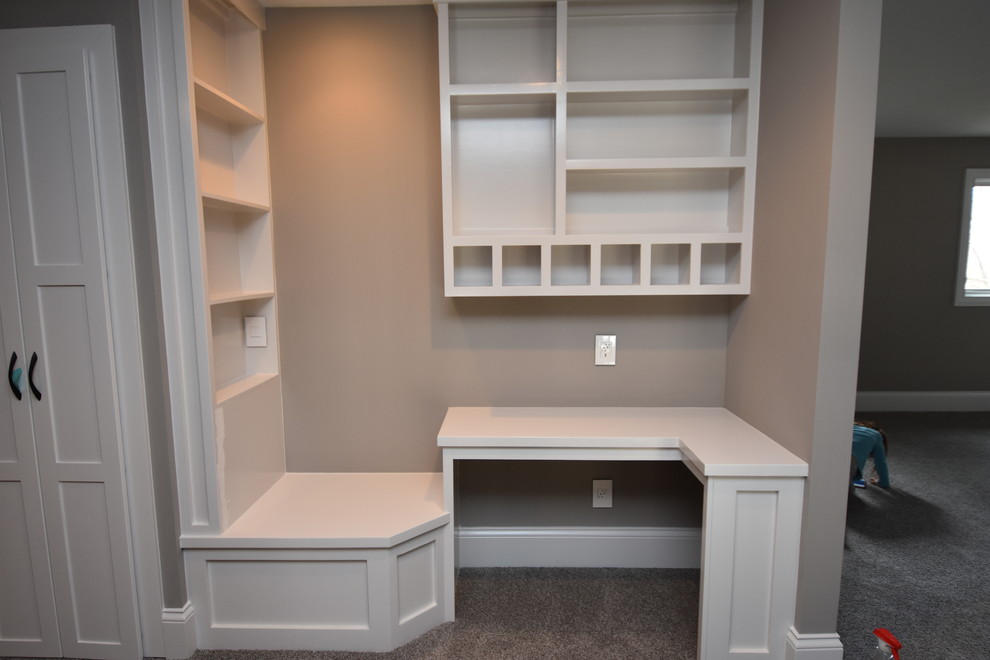 Modelo de despacho de estilo americano pequeño sin chimenea con paredes grises, moqueta y escritorio empotrado