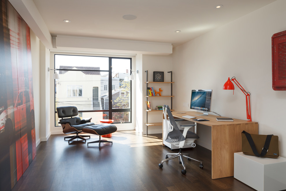 Imagen de despacho actual con paredes blancas, suelo de madera oscura y escritorio independiente