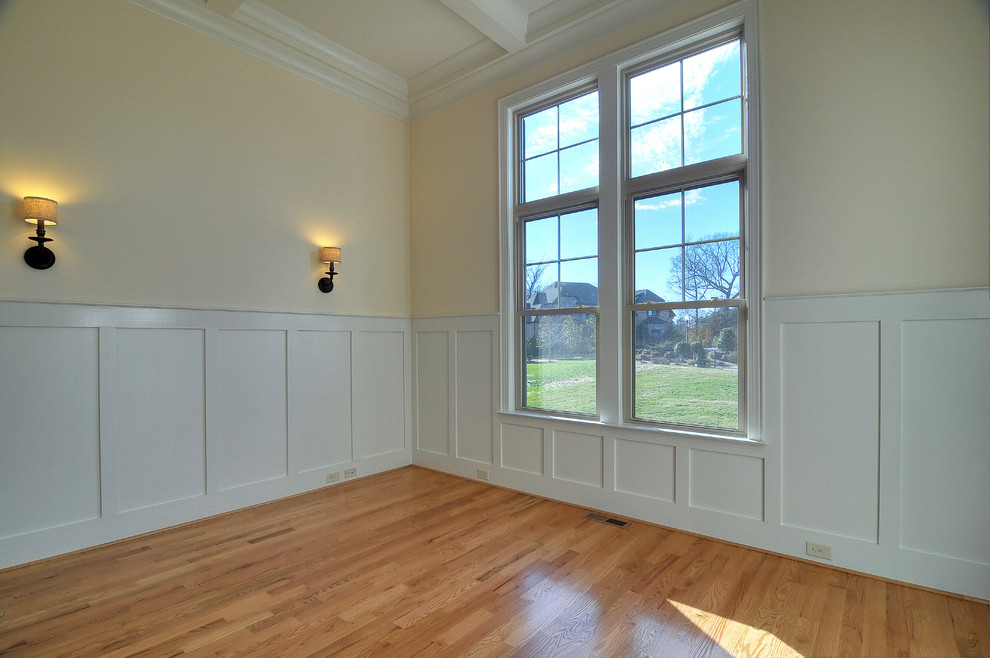 Arbeitszimmer ohne Kamin mit beiger Wandfarbe und hellem Holzboden in Charlotte