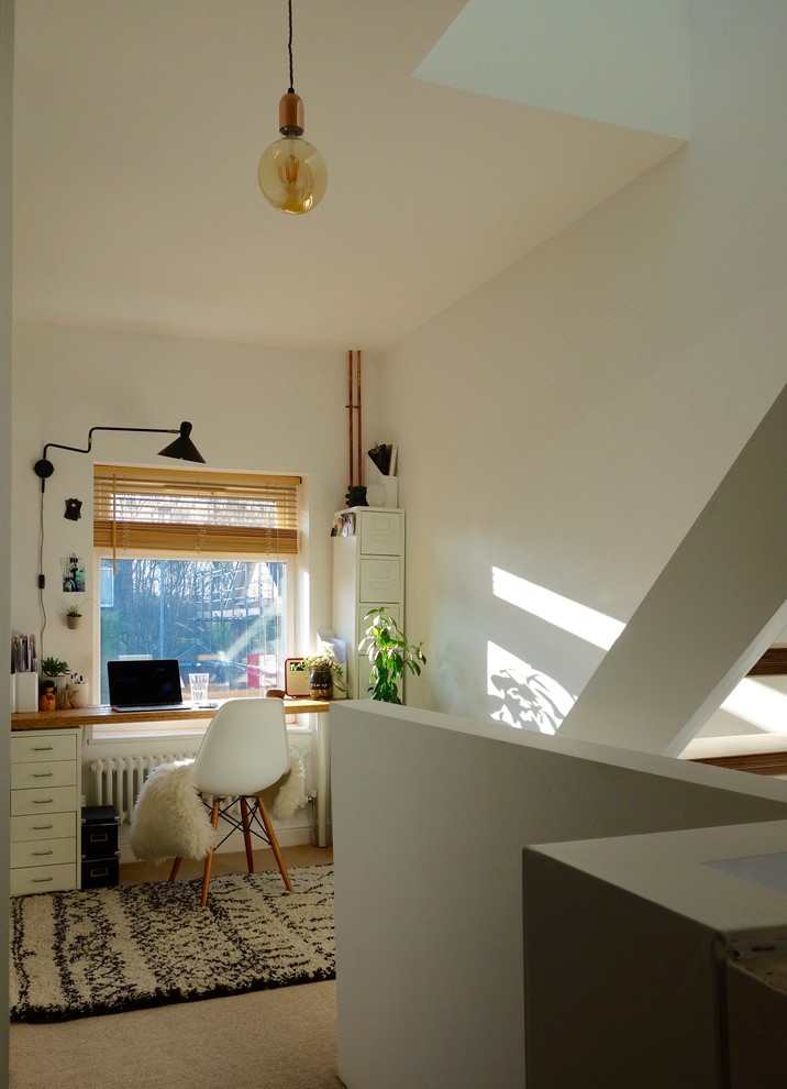 Kleines Nordisches Arbeitszimmer ohne Kamin mit Arbeitsplatz, weißer Wandfarbe, Teppichboden und freistehendem Schreibtisch in Sonstige