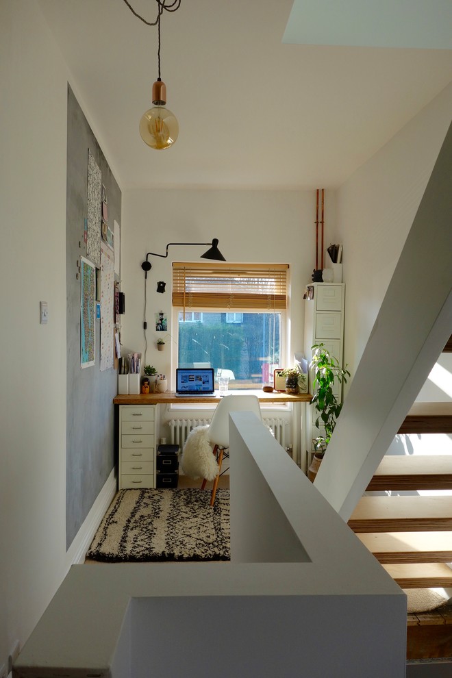 Kleines Skandinavisches Arbeitszimmer ohne Kamin mit Arbeitsplatz, weißer Wandfarbe, Teppichboden und freistehendem Schreibtisch in Sonstige