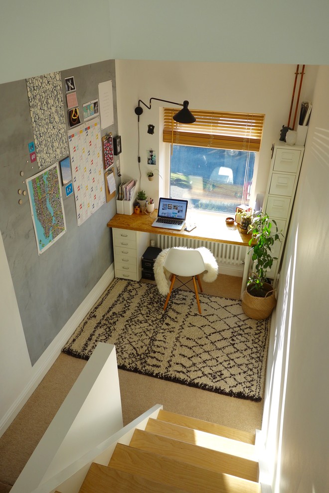 Modelo de despacho nórdico pequeño sin chimenea con paredes blancas, moqueta y escritorio independiente