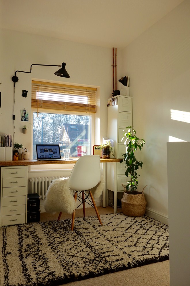 Kleines Skandinavisches Arbeitszimmer ohne Kamin mit Arbeitsplatz, weißer Wandfarbe, Teppichboden und freistehendem Schreibtisch in Sonstige