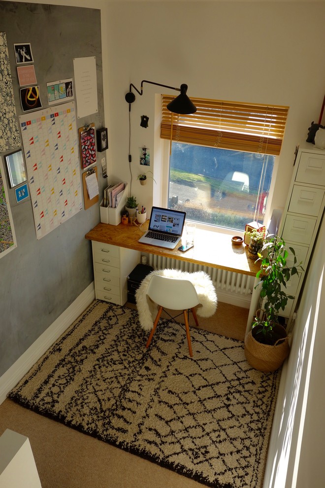 Idéer för ett litet nordiskt hemmabibliotek, med vita väggar, heltäckningsmatta och ett fristående skrivbord