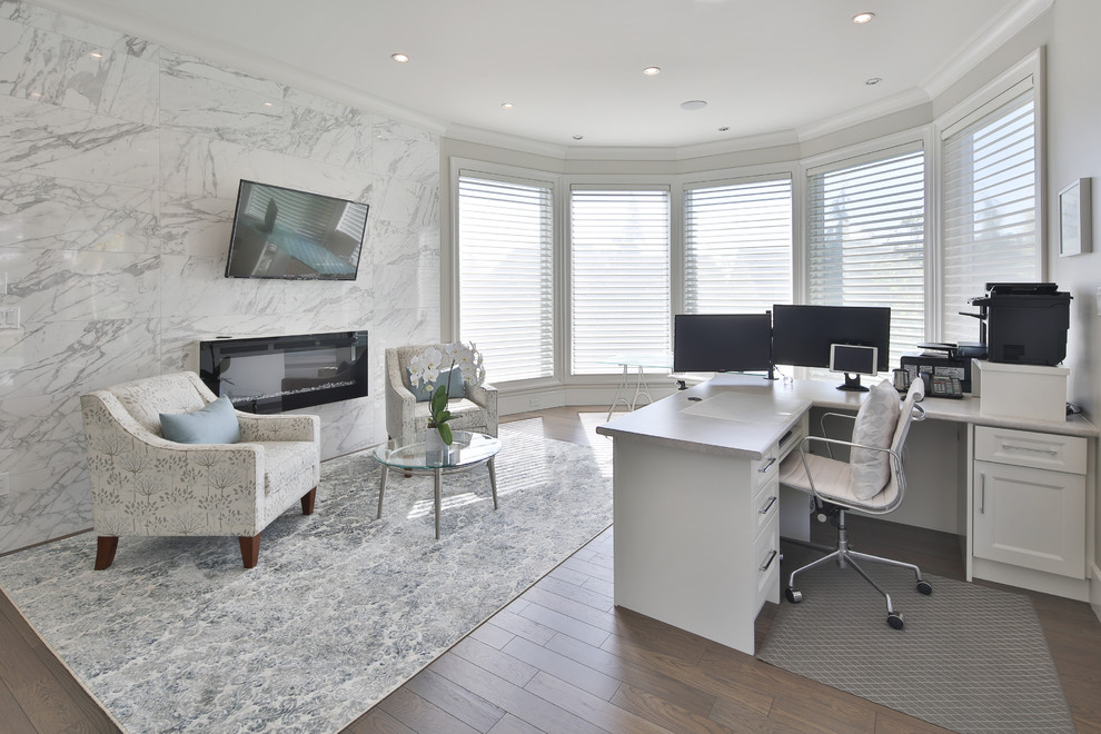 Großes Modernes Arbeitszimmer mit grauer Wandfarbe, Vinylboden, Gaskamin, Kaminumrandung aus Stein, Einbau-Schreibtisch und braunem Boden in Vancouver