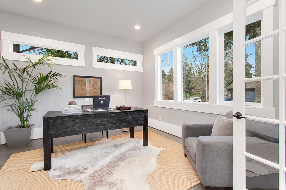 Large classic study in Seattle with grey walls, medium hardwood flooring and a freestanding desk.