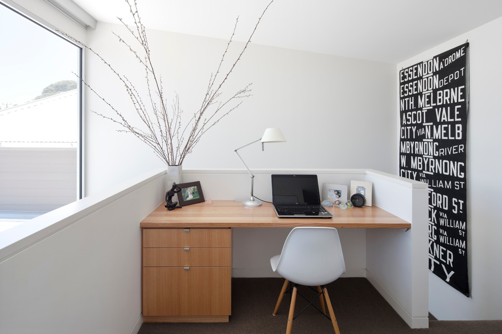 На фото: кабинет в стиле модернизм с ковровым покрытием и встроенным рабочим столом с