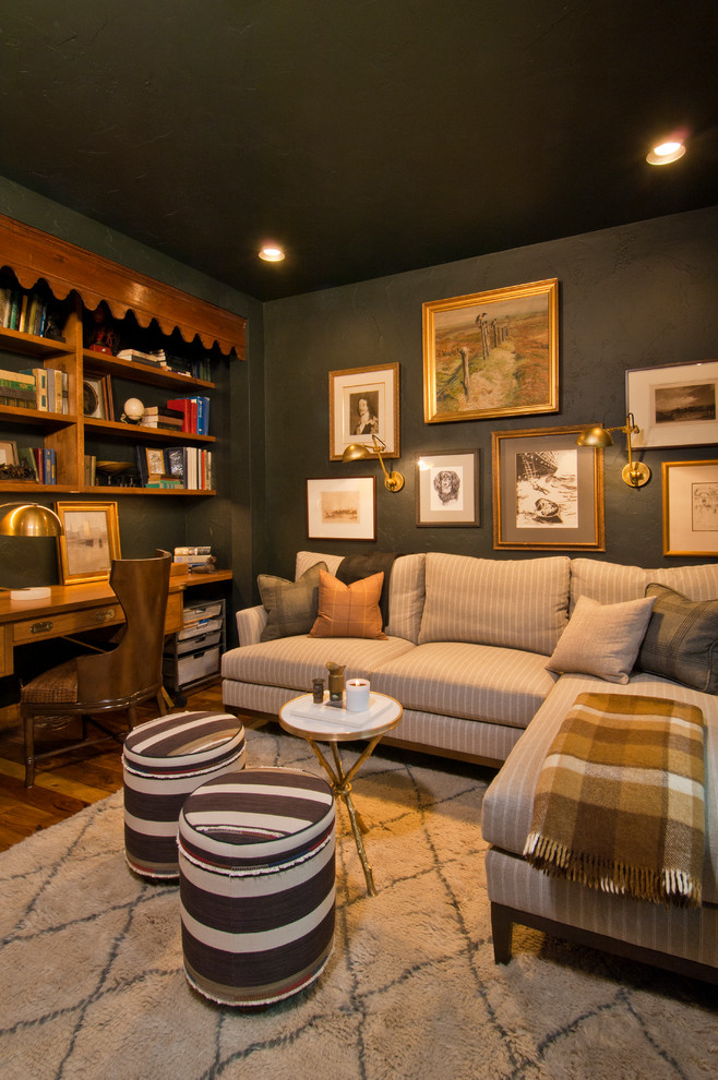 Medium sized eclectic study in Denver with black walls, medium hardwood flooring, a built-in desk and brown floors.