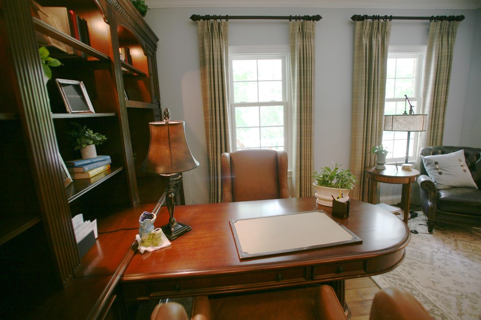 Small traditional study in DC Metro with blue walls, medium hardwood flooring, a freestanding desk and brown floors.