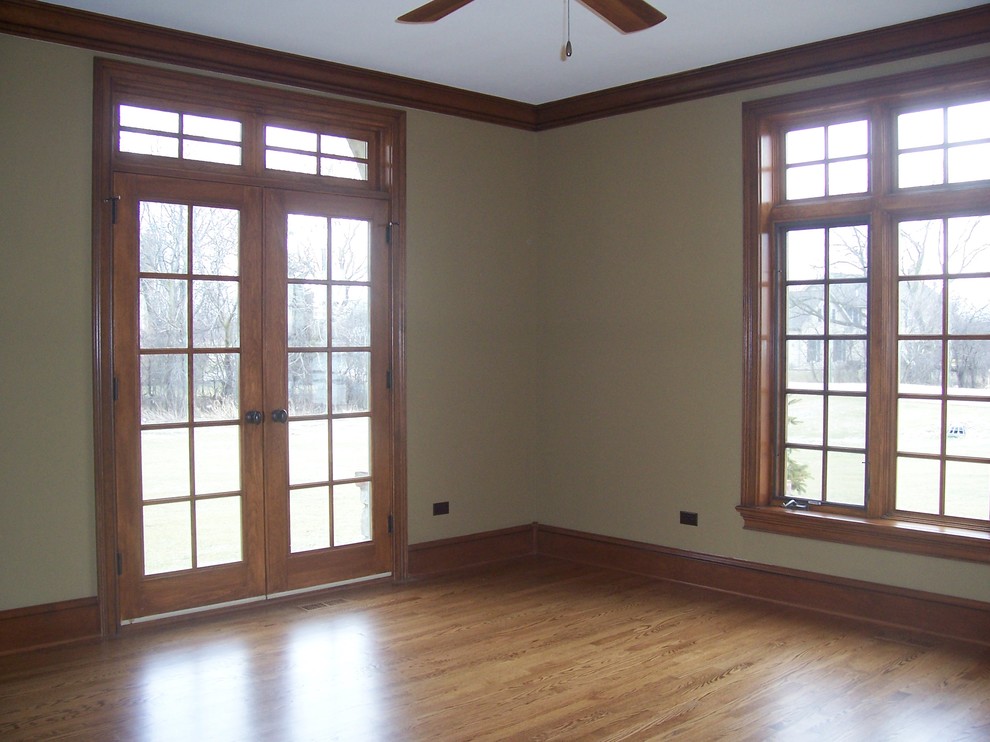 Diseño de despacho tradicional con paredes beige y suelo de madera en tonos medios