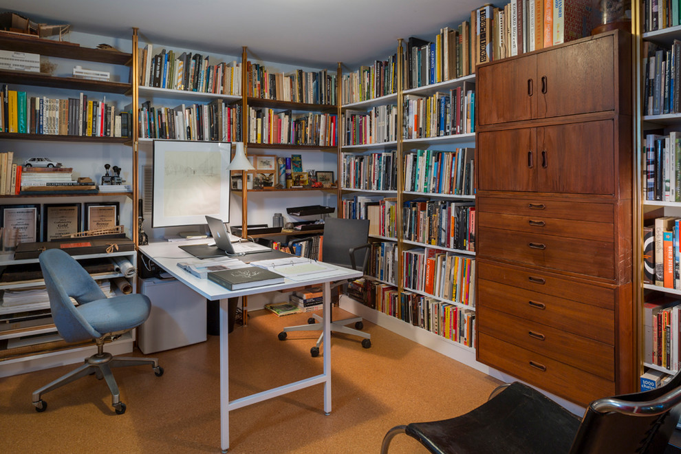 Cette image montre un petit bureau minimaliste de type studio avec un bureau intégré, un mur blanc, un sol en liège et aucune cheminée.