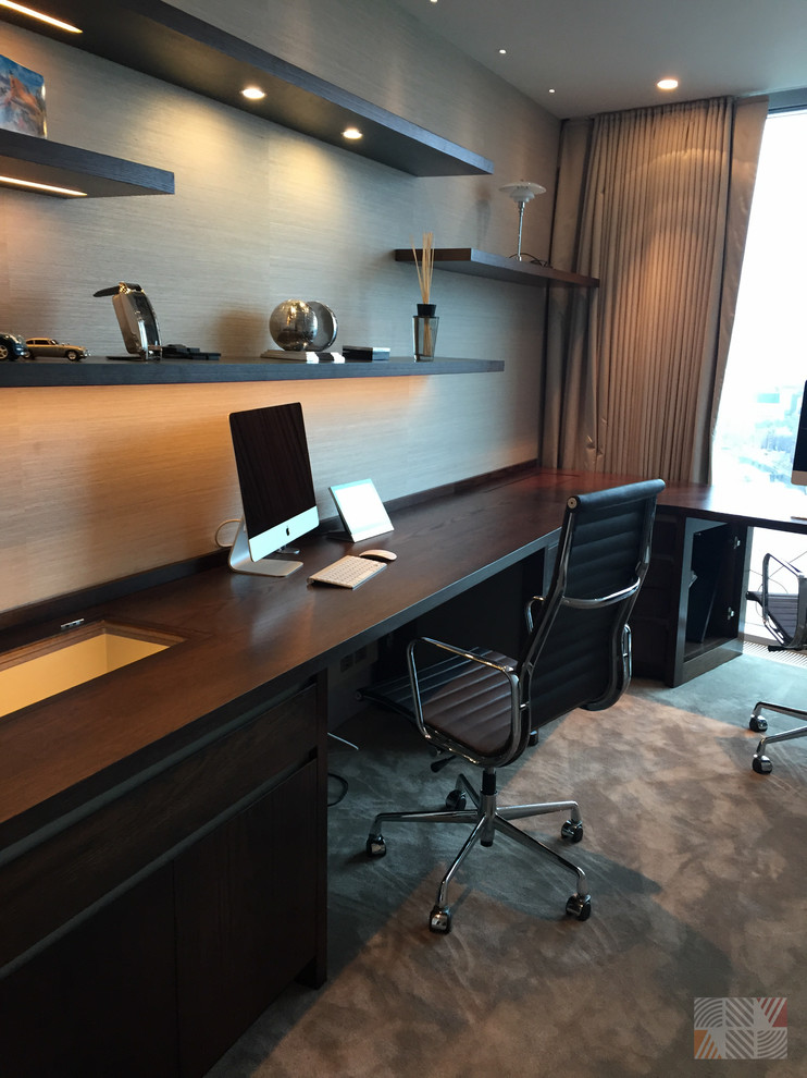 Imagen de despacho actual de tamaño medio con paredes beige, moqueta y escritorio empotrado