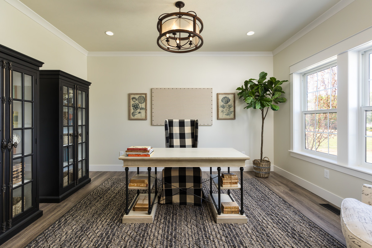 Ejemplo de despacho tradicional con paredes beige, suelo de madera oscura y escritorio independiente