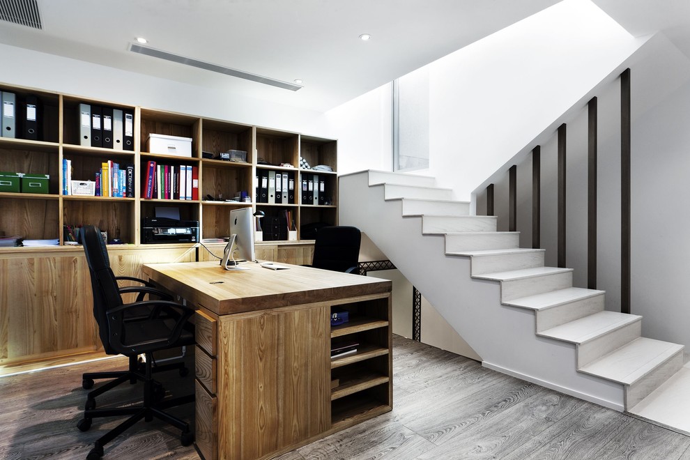 Immagine di uno studio minimal con pareti bianche, scrivania autoportante e pavimento grigio