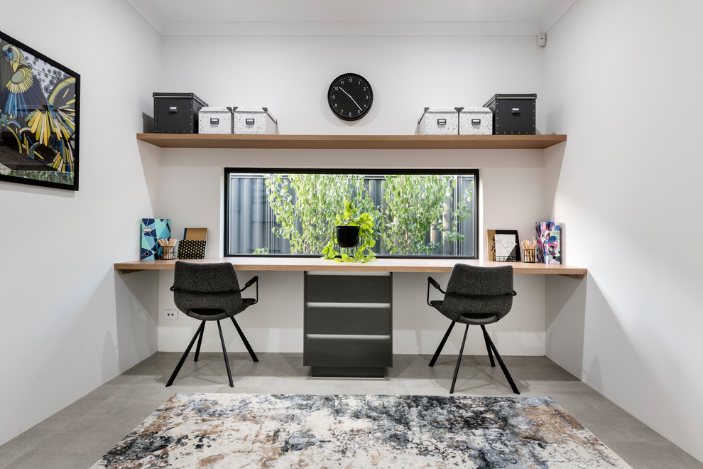 Esempio di un ufficio minimal di medie dimensioni con pareti bianche, pavimento con piastrelle in ceramica, scrivania incassata e pavimento grigio
